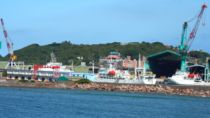 industrial shipyard on the island of Taiwan in the bay of the Pacific Ocean. dock with large ships and cranes on a sunny day. ship repair. asian business 