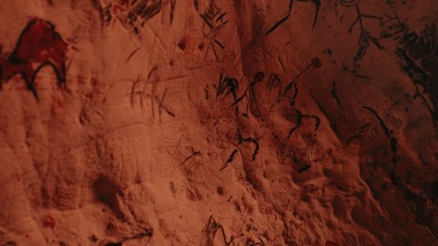 Primitive Prehistoric Neanderthal Drawings of Animals and Abstracts. Bonfire illuminating Walls at Night. Creating First Cave Art with Petroglyphs, Rock Paintings. Tilting Floating Camera Angle