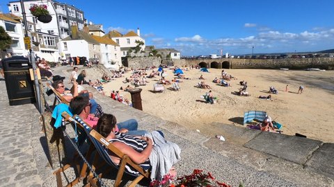 Saint Ive, Cornwall / England - 09/05/2019: People sitting in front of the beach