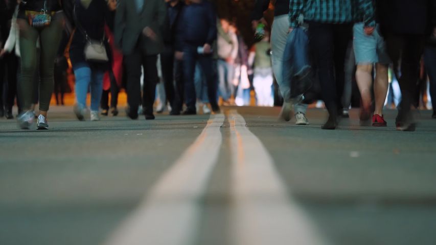 Timelapse: footsteps of crowd of people walking cross dividing strip on road, crowd of people pedestrians walk after festivities, busy night city street. Royalty-Free Stock Footage #1037025176