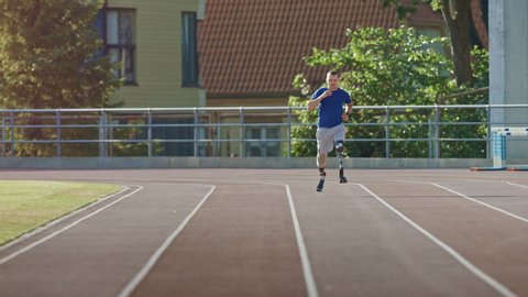 Athletic Disabled Fit Man with Prosthetic Running Blades is Training on a Outdoors Stadium on a Sunny Afternoon. Amputee Runner Jogging on a Stadium Track. Motivational Sports Footage.