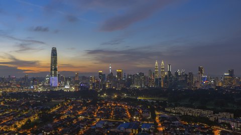 Time lapse: Beautiful and dramatic sunrise view of Kuala Lumpur city skyline from afar and high angle in Malaysia overlooking busy city streets. Zoom out motion timelapse. Full HD.