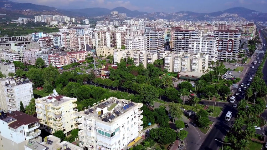 Top view of resort town with hotels on background of mountains. Clip. Beautiful landscape of southern city located in mountains in summer