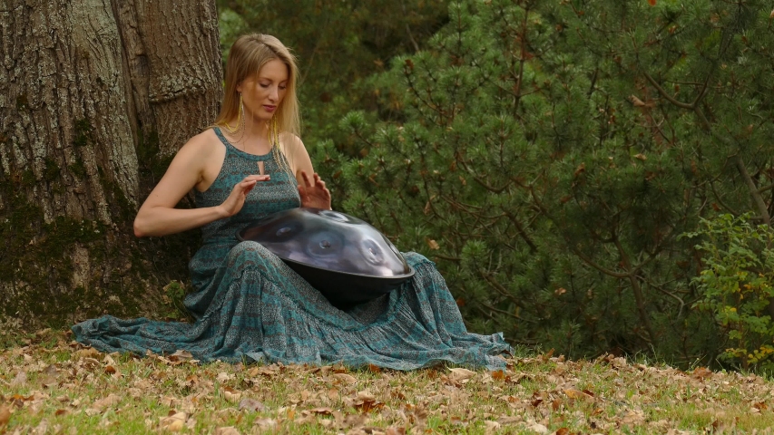 Playing The Instrument Hung. Woman Hands Playing The Hang in park. Sound Meditation