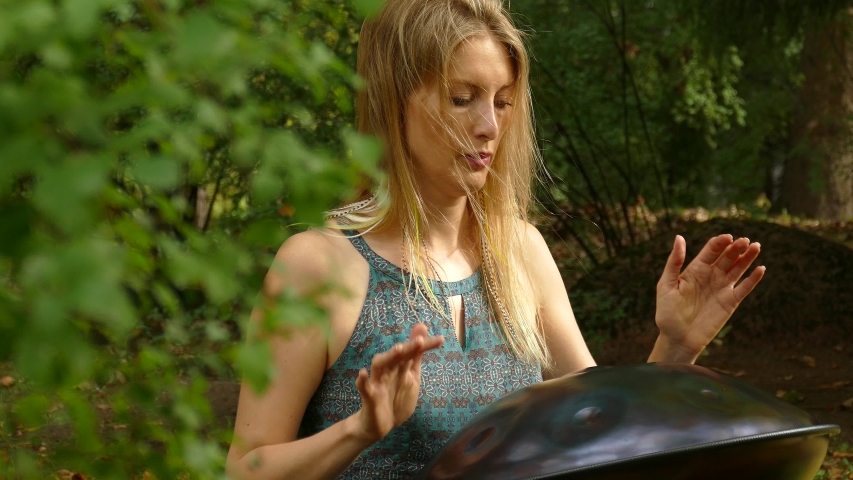 Playing The Instrument Hung. Woman Hands Playing The Hang in park. Sound Meditation