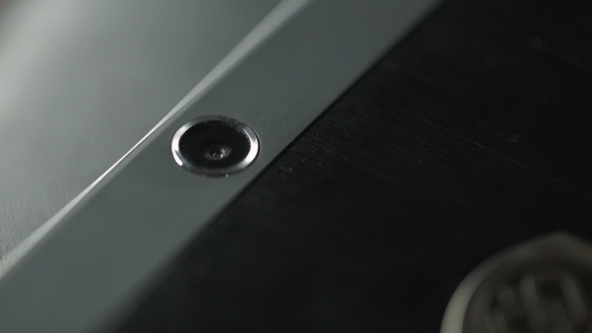 Camera lens on silver mobile phone case. Close up camera on black tablet computer