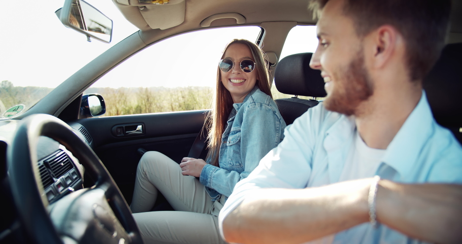 Young fashionable male and female sitting in car and fastening seat belts, safety Royalty-Free Stock Footage #1037050709