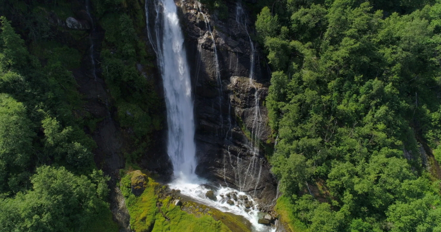 Aerial: Drone shot of beautiful waterfall on cliff amidst trees in forest - Geiranger Fjord, Norway | Shutterstock HD Video #1037051888
