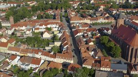 Aerial of the city Beeskow in eastern Germany on a sunny day in summer. Tilt up and descend beside the city.