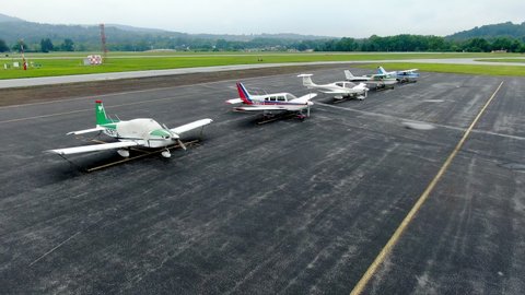 Harrisburg , Pennsylvania / United States - 08 16 2019: Aerial drone point of view of general aviation light propeller airplanes parked on tarmac at Capital City Airport near Harrisburg, Pennsylvania