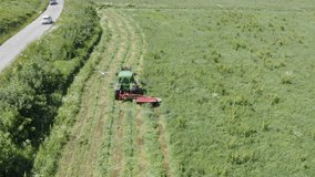 Aerial clip following tractor cutting brush in an overgrown field.