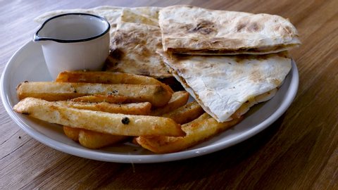 Sprinkle pepper French fries, Quesadilla and french fries on plate