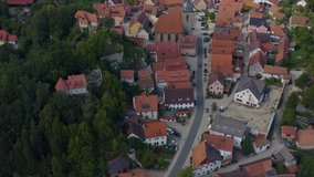 Aerial view of the village Betzenstein in Germany  on a sunny day in summer. Tilt up across the village.
