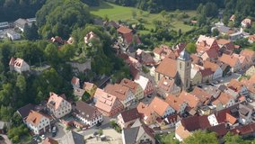 Aerial view of the village Betzenstein in Germany  on a sunny day in summer. Pan to the left at the end of the village.