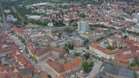Aerial view of the city Bayreuth in Bavaria, Germany on a cloudy day in summer. Pan to the left across the old town.