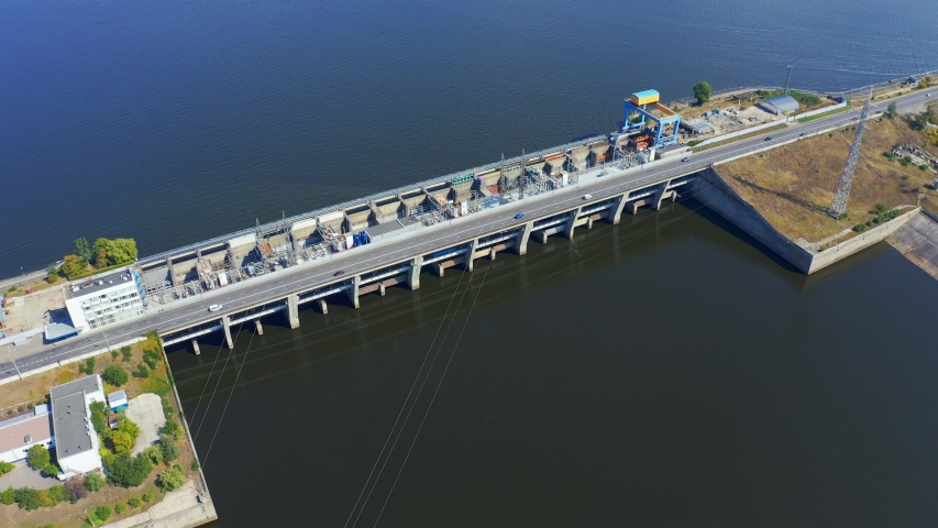 Cars ride along the dam of the Kiev hydroelectric station. Power plant on the Dnieper River in Vyshgorod, Ukraine. Aerial view 4k