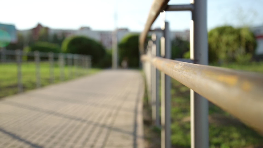 sporty lady puts foot on metal handrails ties brand sneaker laces and runs away along wooden bridge slow motion