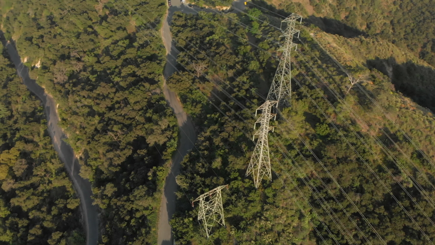 Aerial Rotation Around Power Lines on a Verdant Mountain