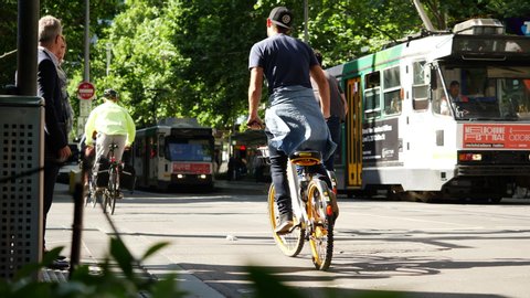 Melbourne, Victoria / Australia - September 2018: Bicycles track, trams, a runner and pedestrians in the Central Business District during a sunny day of spring.