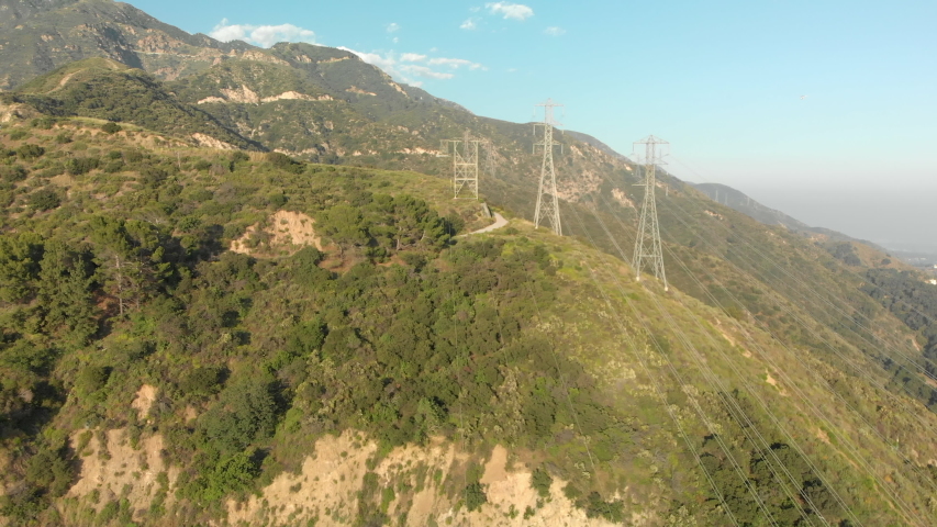 Aerial of Power Lines on a Verdant Mountain
