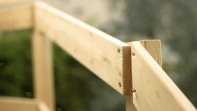 Adult carpenter craftsman with screwdriver screw the screw to fix the boards of a wooden fence. Housework, do it yourself. Footage.