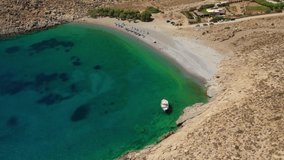 Aerial drone video of paradise organised beach of Kaminakia with emerald clear sea and small caves, Astypalaia island, Dodecanese, Greece