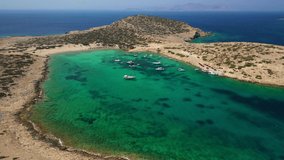 Aerial drone video of paradise beach of Kalotaritissa with emerald clear sea, Amorgos island, Cyclades, Greece