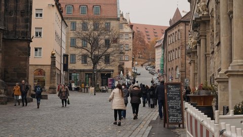 NUREMBERG, GERMANY - November 30, 2019: Right to left pan real time establishing shot of people walking around the old town of Nuremberg, November 30, 2019 in Nuremberg, Germany.