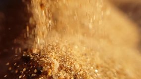 A closeup video of golden sand falling in slow motion