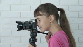Girl videographer. A surprised child with videography equipment shoot video in the room.