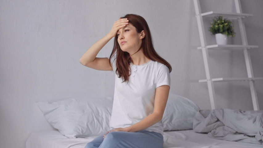 sick woman measuring temperature in bed