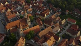 Aerial view of the city Feuchtwangen in Germany, Bavaria  on a sunny day in summer. Pan to the right around the side part of the churches.