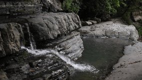 4K video waterfalls. Several levels of waterfalls. Video with waterfalls. video of flowing water, flowing stream among stones. Stream in the forest