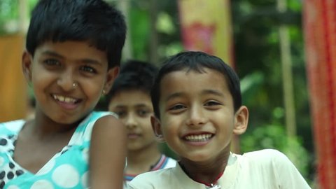 Happy kids in a village in India laughing and smiling together. Narrow depth of field.