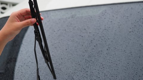 The woman's hand remove the old wiper of the car, Rainy season should always be changed or maintained by car wipers, For driving safety.