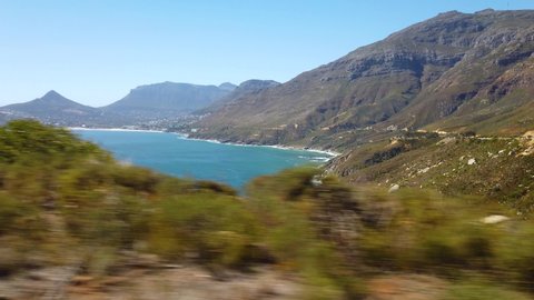 POV footage from a car ride along the hilly shoreline near Cape Town, South Africa. Camp's Bay and Lion's Head visible.