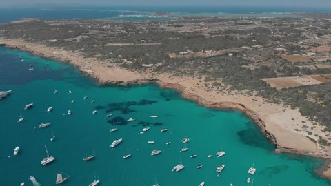 Aerial View of many yachts in a bay on Formentera island. Cala Saona bay drone footage. Yachting in the Balearic islands