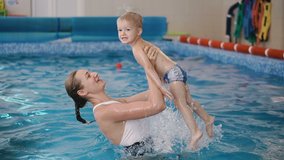 Video clip. Mom teaches a child to swim in the pool.