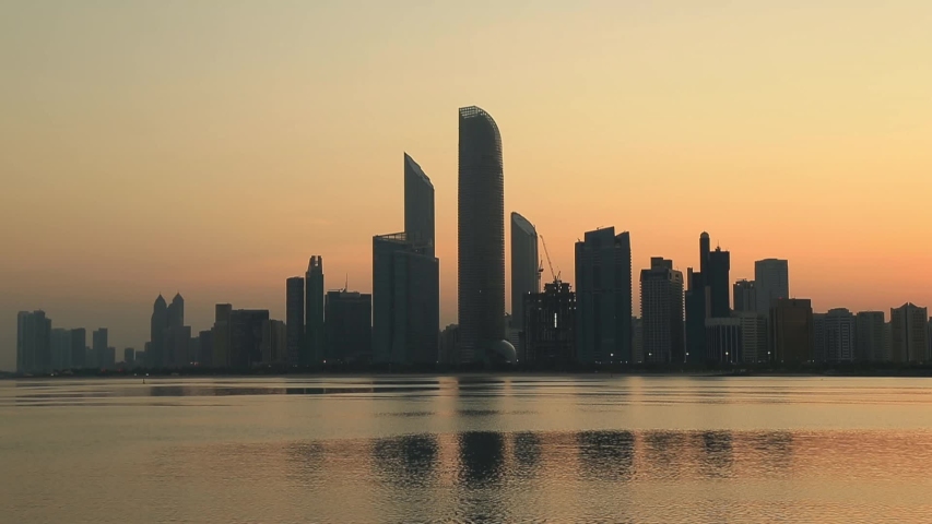 Sunrise in Abu Dhabi, United Arab Emirates. Birds flying across the frame.