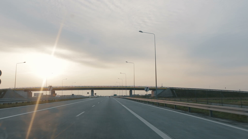 POV driving along a wide empty morning road early in the morning during sunrise.. Point of view driving, view from inside the car on on the autobahn in Poland. Royalty-Free Stock Footage #1037223665