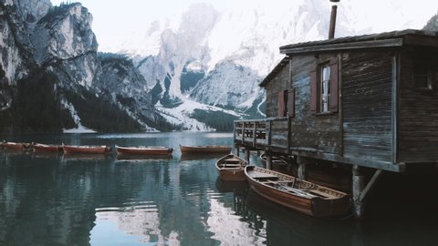 Scenic view of old boat house with traditional wooden rowing boats at famous Lago di Braies in the Italian Dolomites illuminated in first morning light at sunrise, South Tyrol, northern Italy