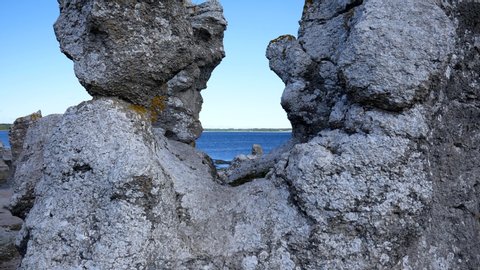 Rising shot showing the coastline of Gotland revealing the sea between some rock formation created by erosion. Filmed in realtime, camera moves upwards.