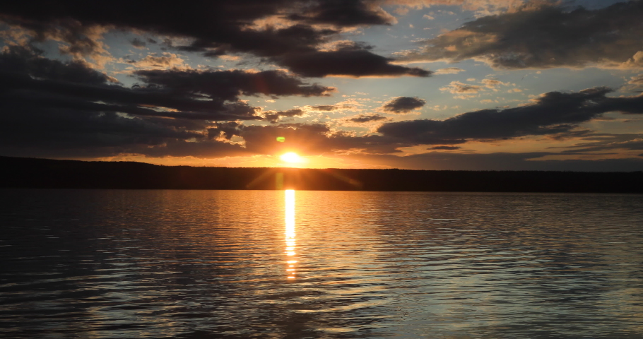 Yellowstone National Park Wyoming sunset lake clouds. Beautiful sunset over high Rocky Mountain lake. Geography, geology, natural beauty, wildlife and tourism.