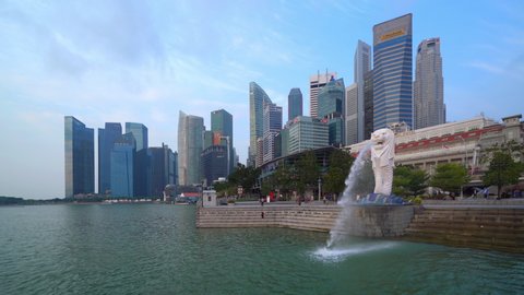 Singapore  - 09/14/2019 : Merlion with skyscraper buildings in Singapore City at noon. Financial district in downtown with business centers in technology smart urban city in Asia.