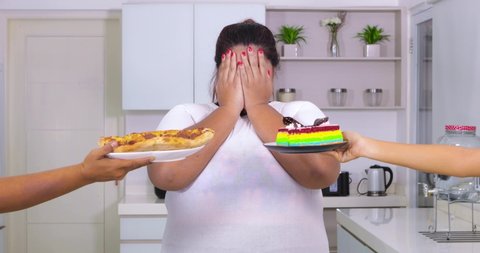 Overweight woman rejecting to eat pizza and cake by closing her face for dieting. Shot in 4k resolution at home