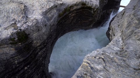 Glacial Waters Gushing Through A Rock Crevasse CLOSE UP. Natural Bridge at Yoho National Park