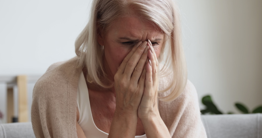 Upset depressed mature old woman crying alone at home thinking of loneliness or grief, sad middle aged senior woman in tears worried about health problems mourning feeling lonely miserable concept | Shutterstock HD Video #1037252564