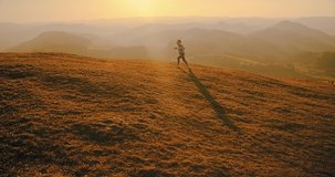 Children running outside. Happy traveler boy playing on sunny day in park. 4K slow motion video. Child runs on top of mountain at sunset. Journey to the Edge of the Universe
