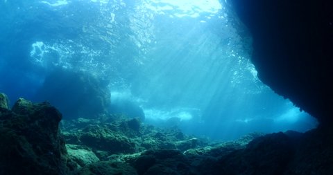 underwater landscape scenery with rocks and blue water sun beams and sun rays backgrounds