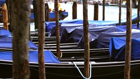 Traditional gonodola boats tied to pier in rainy day in Venice.Exotic long black bloat for tourist attraction.Popular travel destination in Europe for cultural tourism.Rent water taxi on Venezian pier
